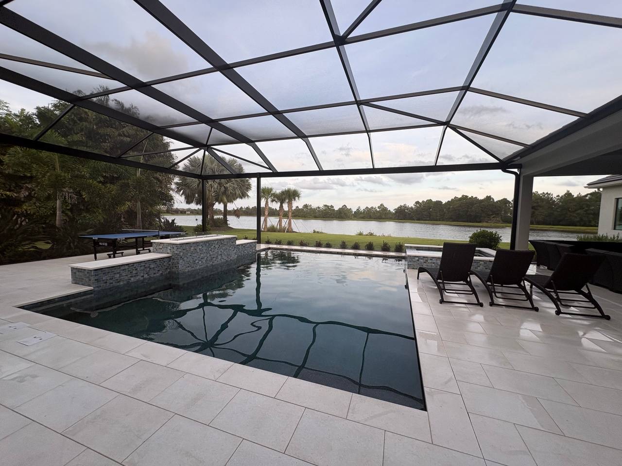 Pool and tiled deck inside a screened enclosure