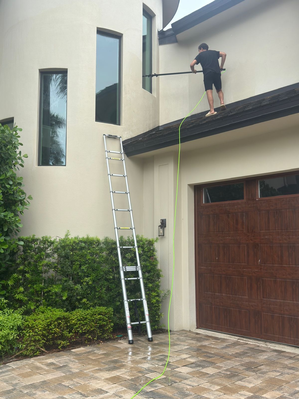 Elite Shine technician using a water-fed pole on upper windows